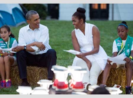 صور.. باراك أوباما وزوجته يلعبان مع فرقة الكشافة